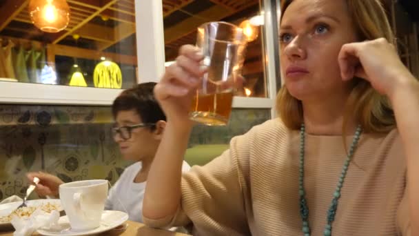 Mère avec son fils assis au restaurant. avec un appétit manger. 4k — Video