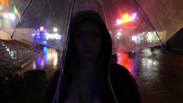 Silhouet van een man in een capuchon staande op een straat van de nacht. 4k — Stockvideo