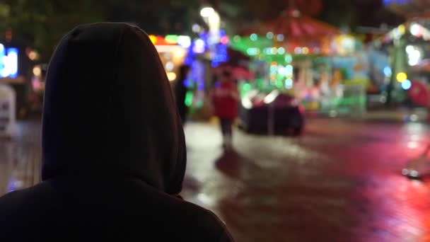 Siluet seorang pria berkerudung berdiri di jalan malam. 4k — Stok Video