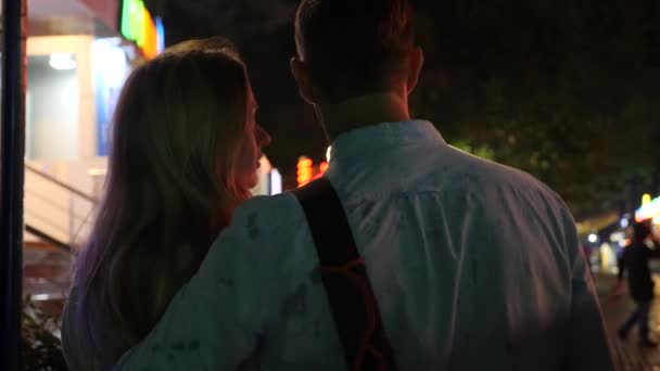 Città di notte con le luci. In coppia d'amore baciarsi sullo sfondo della città di notte. Sfocatura dello sfondo. 4k — Video Stock