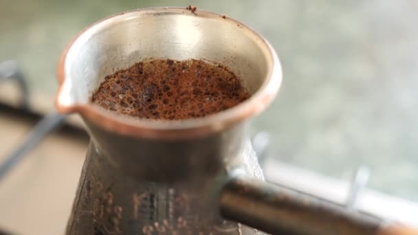 Hervir el café de los turcos. En la estufa de gas hay un turco grabado en cobre con un café en circulación. Haciendo café de cerca. lapso de tiempo — Vídeos de Stock