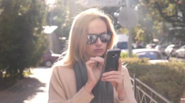 Şehir, 4 k bir alışveriş alanında duran bir akıllı telefon kullanan genç kadın. Ağır çekim