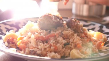 biri Ulusal mutfağı bir restoranda pilav yiyor. 4k, ağır çekim