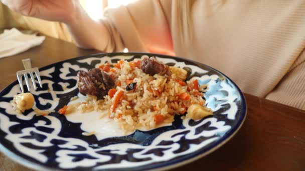 Iemand eet pilaf in een restaurant van nationale keuken. 4k, slow-motion — Stockvideo