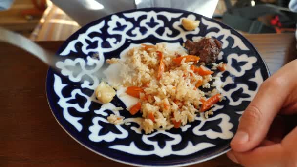 Biri Ulusal mutfağı bir restoranda pilav yiyor. 4k, ağır çekim — Stok video