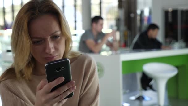 Vrouw maakt gebruik van een smartphone in luchthaven wachten lounge. Verwachtingen van de vlucht op de luchthaven. 4k, slow-motion — Stockvideo