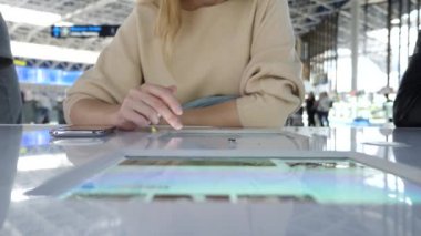 Kadın bir smartphone Havaalanı lounge bekleyen kullanır. Havaalanında uçuş beklentilerini. 4k, ağır çekim