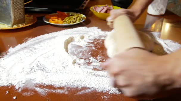 Der Mann knetet den Teig, kocht Pizza, die Familie kocht in der Küche. 4k. Nahaufnahme — Stockvideo