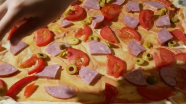 yakın çekim, eller üzerinde hamur pizza için dolgu yayıldı. pişirme pizza, Aile mutfakta yemek pişiriyor. 4k