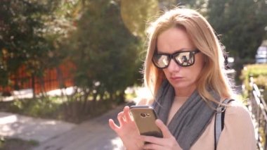 Şehir, 4 k bir alışveriş alanında duran bir akıllı telefon kullanan genç kadın. Ağır çekim