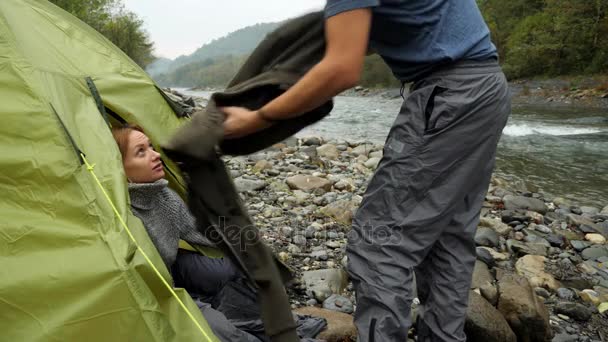 4 k. en kille och en tjej nära turist tält på en berg-floden. — Stockvideo