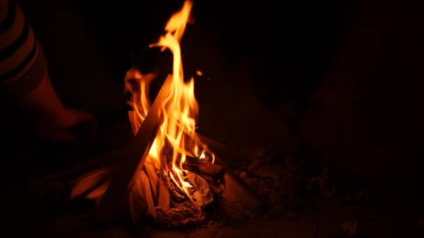 Ogień w kominku. 4k, zwolnionym tempie. Kobieta kładzie drewno w kominku — Wideo stockowe
