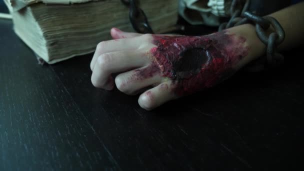 A terrible hand with a bloody wound is chained to an iron chain. hand monster on halloween. 4k, slow motion — Stock Video