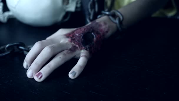 Una mano terrible con una herida sangrienta está encadenada a una cadena de hierro. monstruo de la mano en Halloween. 4k, cámara lenta — Vídeos de Stock