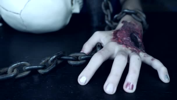 Een verschrikkelijke hand met een bloederige wond is geketend aan een ijzeren ketting. hand monster op halloween. 4k, slow-motion — Stockvideo