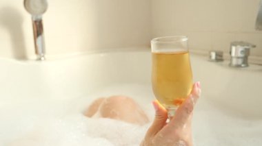 banyo yaparken şarap içme kadın sarışın. 4k, ağır çekim