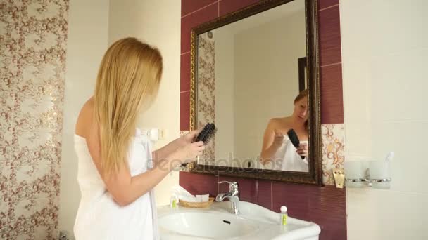 女性の濡れた髪をドライのゆっくりした動きです。女性の女性は、バスルームにヘアドライヤーを使用します。4 k — ストック動画