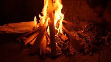 Bir şömine ateş. 4k, ağır çekim. kadın yakacak odun şöminede koyar.