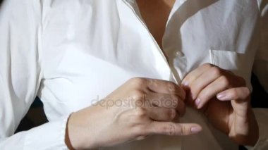 yakın çekim, ayrıntılar. bir kadın onun beyaz gömlek üzerinde üst düğmesini unfastens, onu kaldırır. 4k, ağır çekim