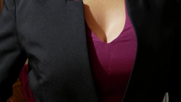 Женщина с красивой грудью надевает черную куртку — стоковое видео