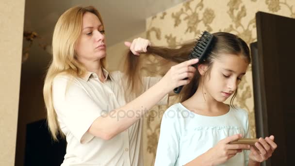 妈妈梳她女儿的头发。长发。4k 慢动作复制空间. — 图库视频影像