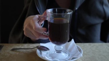 4k, ağır çekim. Birisi şeffaf cam çay içer