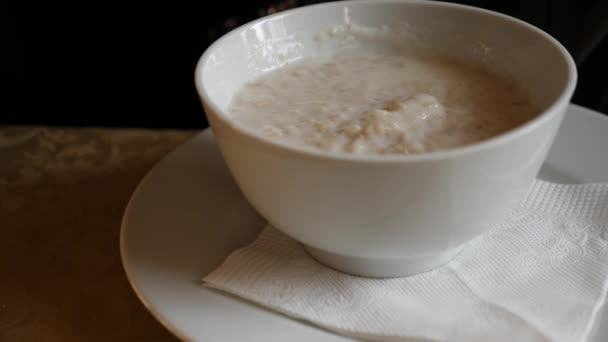 Someone is eating hot oatmeal for breakfast in a cold cafe. 4k, slow motion — Stock Video