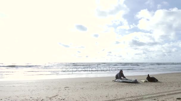 Stan na pláži u moře. 4k, zpomalené. člověk nastaví stan slunečníkem na písečné pláži — Stock video