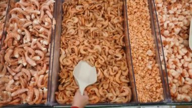 Gıda Market sayaçta taze çiğ deniz ürünleri. Ağır çekim. bir el kadar karides sayaç bir kepçe ile alıyor. 4k.