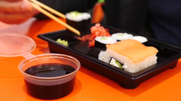 Někdo jí válce sushi. Zblízka. 4k, pomalý pohyb — Stock video