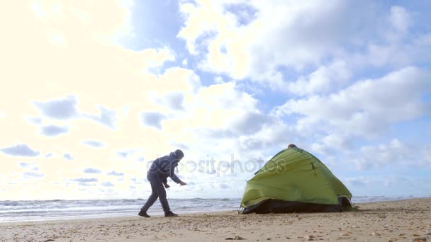 Camping tente sur la plage au bord de la mer. 4k, au ralenti. homme et femme installent une tente sur la plage . — Video