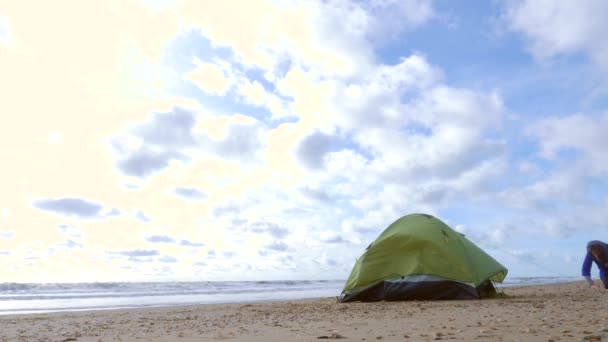 Denizin kenarında plajda kamp çadır. 4k, ağır çekim. Sahilde çadır kurmak kadın. — Stok video