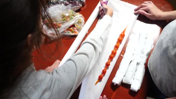 Mutter und Tochter sammeln ein Päckchen mit orientalischen Süßigkeiten und Früchten. 4k, Zeitlupe — Stockvideo