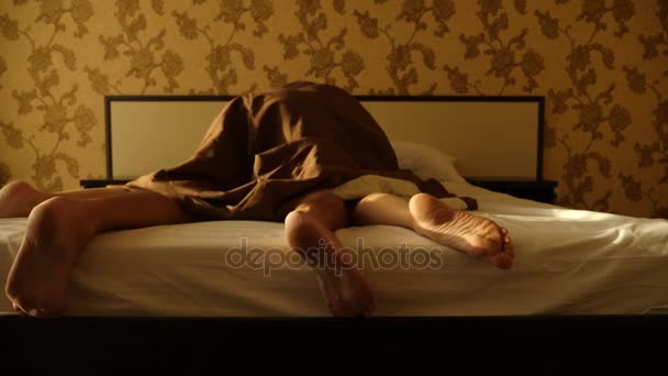 Pár ágyban szeretkezés. férfi és női lábak felülről, fehér ágynemű. szex. 4k, lassú mozgás — Stock videók