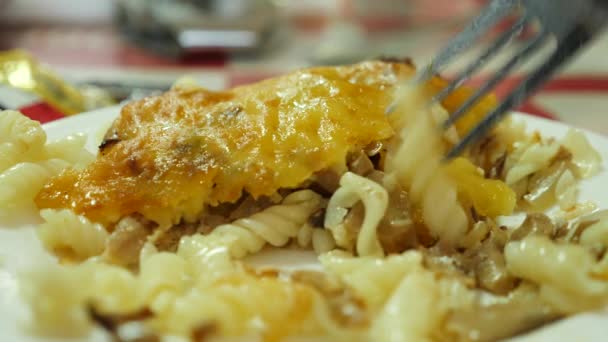 Någon är att äta en kotlett med svamp med en kniv och gaffel i en restaurang. 4 k, slow motion, närbild. — Stockvideo