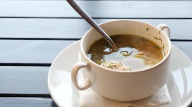 kız sıcak tavuk çorbası bir kafede açık havada yiyor. 4k, ağır çekim. yakın çekim