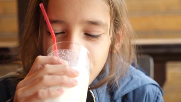 Kind trinkt einen Milchshake durch einen Strohhalm, Nahaufnahme, 4k Zeitlupe. — Stockvideo
