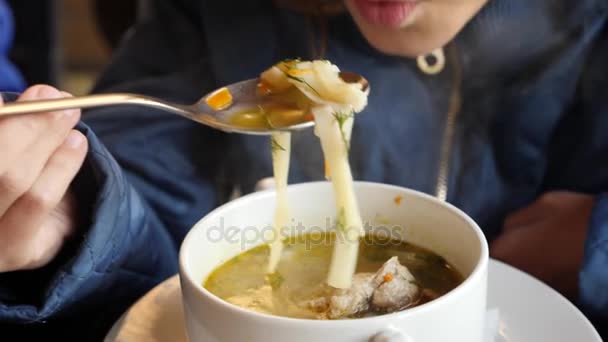 La chica está comiendo sopa caliente de fideos de pollo en un café al aire libre. 4k, cámara lenta. primer plano — Vídeo de stock