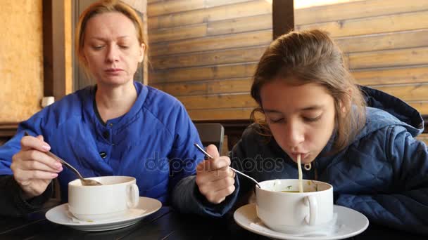 Девушка ест горячий куриный суп с лапшой в кафе на открытом воздухе. 4К, замедленная съемка. макро — стоковое видео