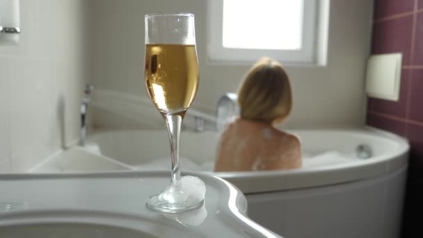 Mujer rubia bebiendo vino mientras toma un baño. 4k, cámara lenta — Vídeos de Stock