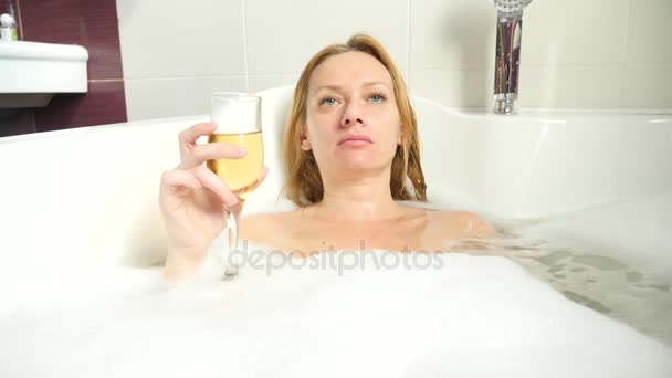 女金发女郎在洗澡的时候喝葡萄酒。4k、慢动作 — 图库视频影像