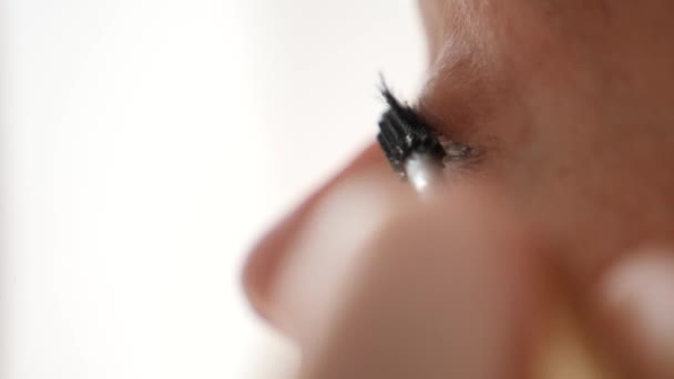 Eye in macro footage of young woman applying mascara on eyelashes. 4k, slow motion — Stock Video