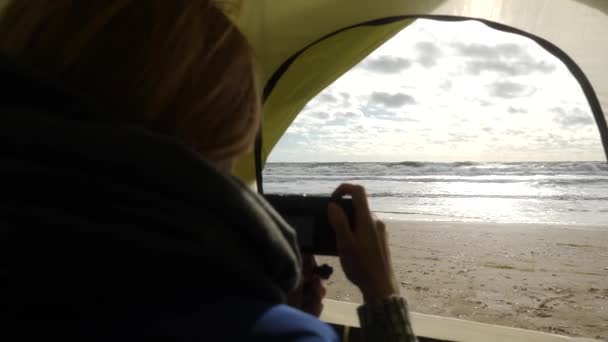 Tenda campeggio sulla spiaggia in riva al mare. 4k, rallenta. una donna spara video da una tenda sulla costa del mare — Video Stock