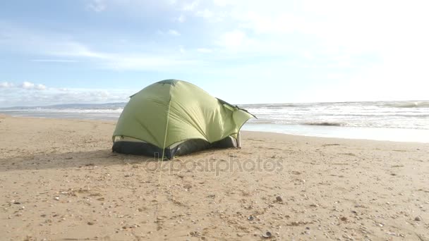 Tenda de acampamento na praia junto ao mar. 4K, câmara lenta. homem montou uma tenda na praia . — Vídeo de Stock