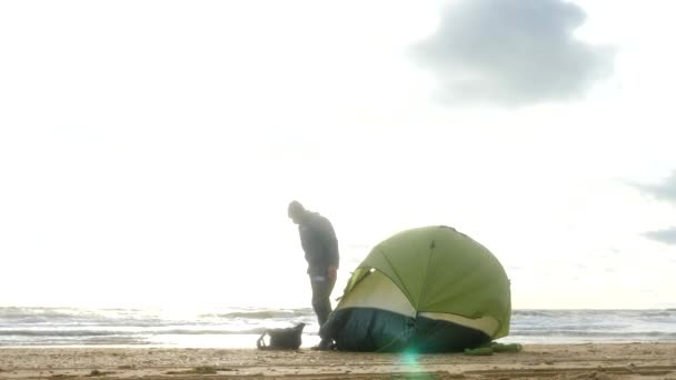Denizin kenarında plajda kamp çadır. 4k, ağır çekim. adam sahilde çadır kurmak. — Stok video