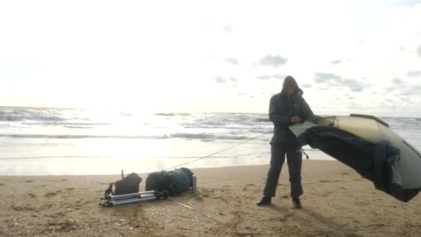 Tenda campeggio sulla spiaggia in riva al mare. 4k, rallenta. uomo allestito una tenda sulla spiaggia . — Video Stock