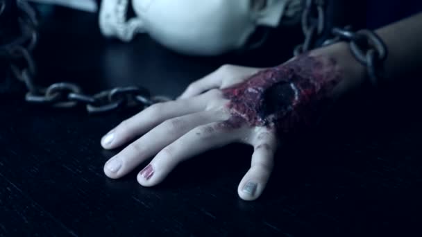 Una mano terribile con una ferita sanguinante è incatenata ad una catena di ferro. Mostro della mano ad Halloween. 4k, rallentatore — Video Stock