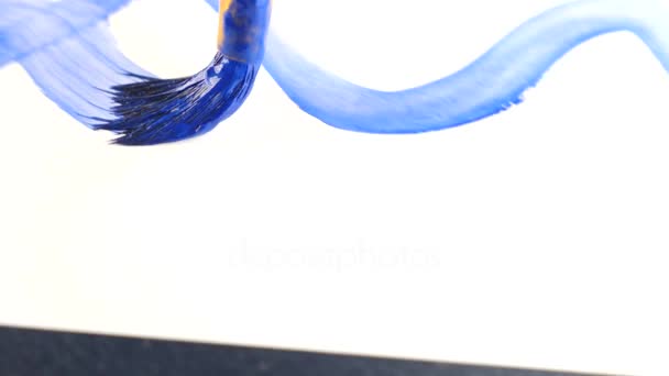 Någon drar färg på ett vitt ark. närbild av en tofs. 4k, ultrarapid, ritar ett blått hav på ett vitt ark — Stockvideo
