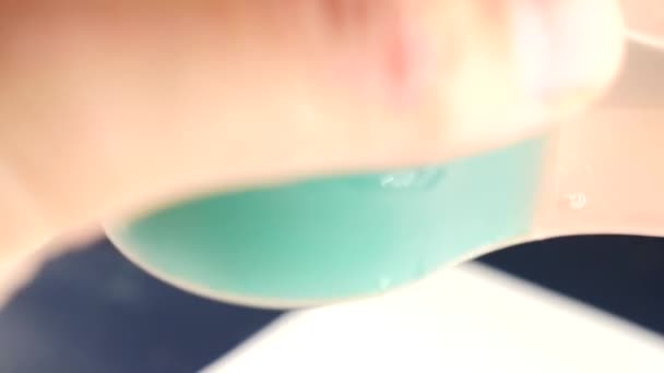 Schar een penseel in een pot met groene verf. iemand trekt verf op een wit vel. Close-up van een kwast. 4k, slow-motion — Stockvideo