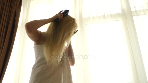 Медленное движение женских влажных волос. Женщина пользуется феном в ванной комнате. 4k slow motion . — стоковое видео